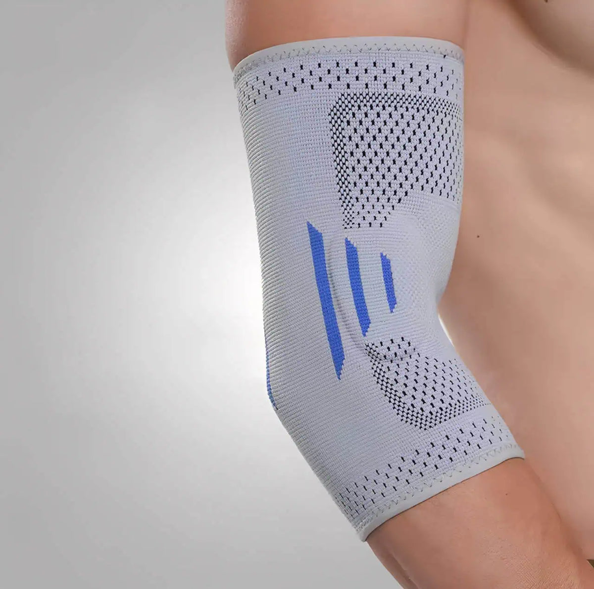 Grått elastiskt armbågsskydd med kompression och ventilerande stickad konstruktion runt armbågen.