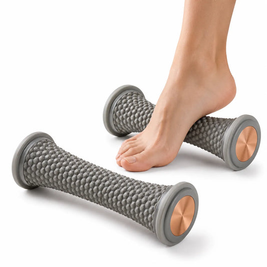 Fot som använder två grå massage- och triggerpunktsrullar för avslappning och cirkulation mot vit studiobakgrund.