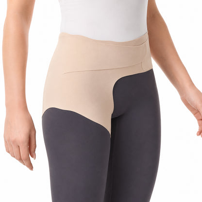 Person bär ett mjukt höftstöd med kompression och kroppsnära passform runt höft och bäcken.