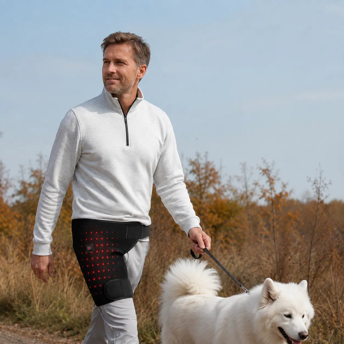 Man använder höftvärmare med rött LED-ljus under promenad utomhus.