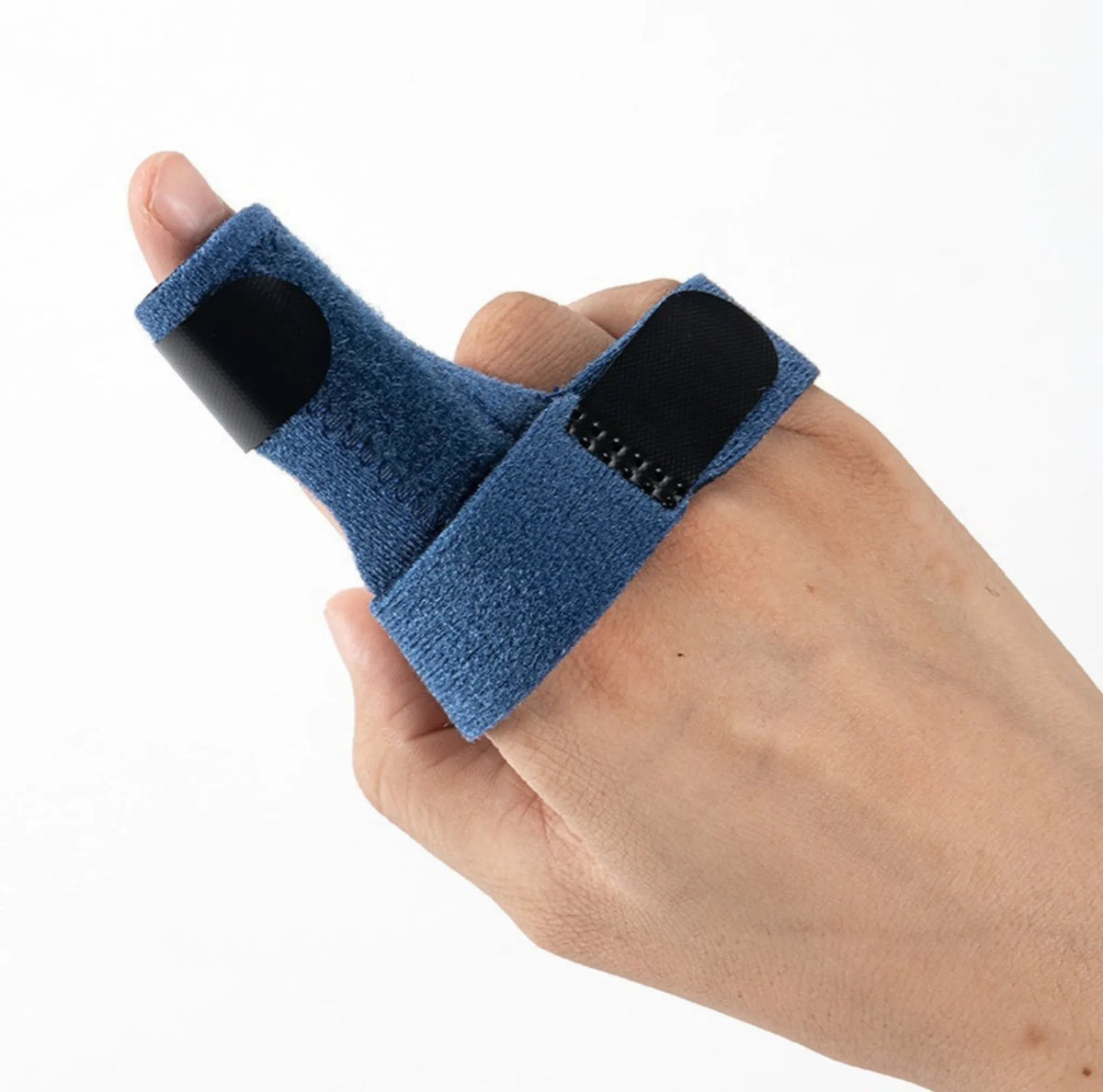 Fingerstöd i tyg med kardborreband sett uppifrån på handen.