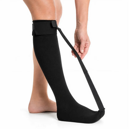 Person med svart stretchsocka och justerbar rem från tå till underben.