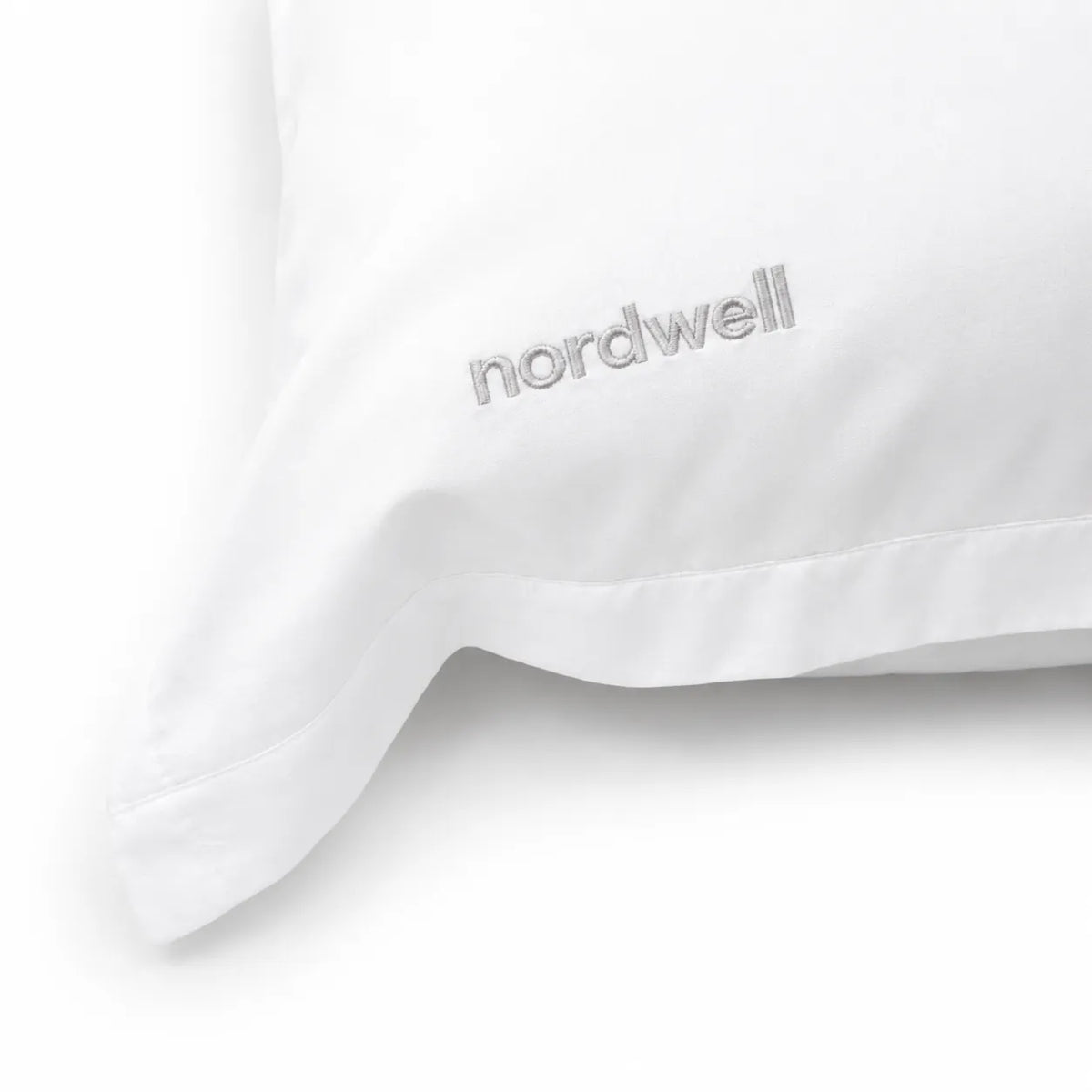 Närbild på mjuk polyester-satin och broderad logotyp